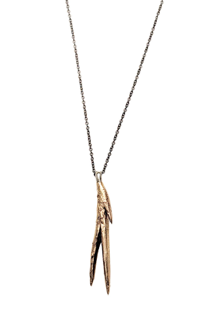 Natural bronze casting of a succulent aloe leaf pendant with a black oxidized sterling silver chain. Long black and gold handmade necklace by J'Adorn Designs jewelry artist Alison Jefferies.