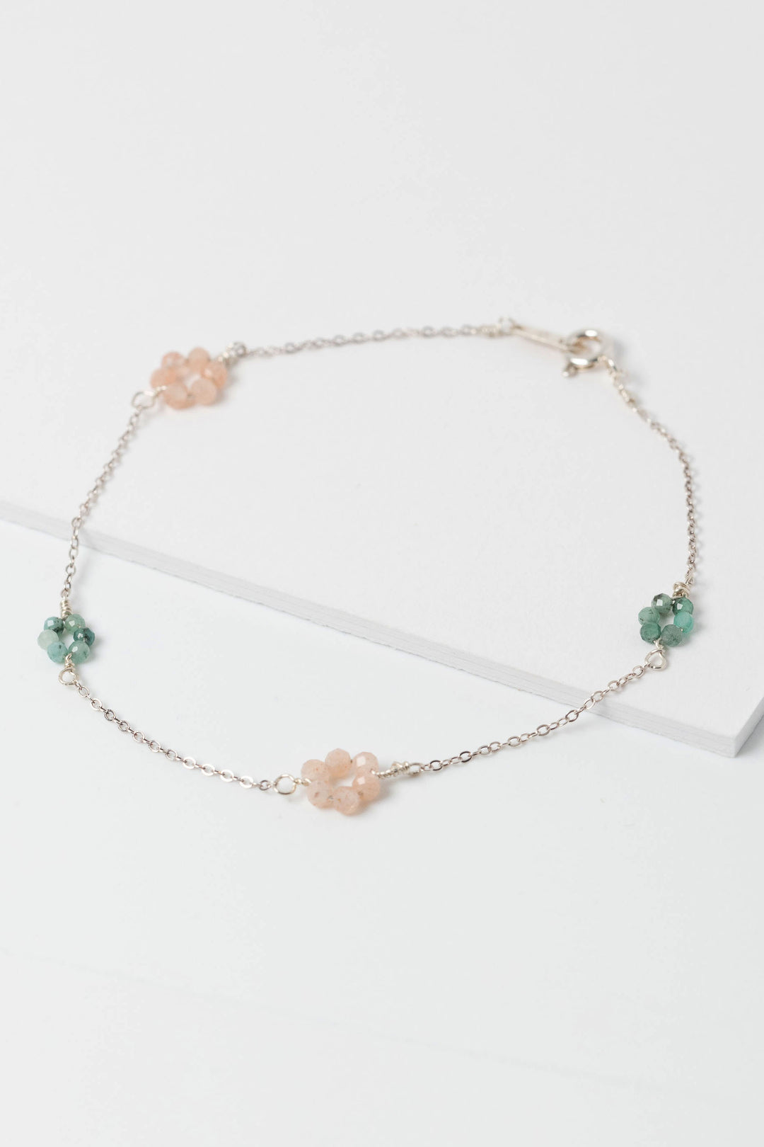 Delicate pink and green "daisy chain" sterling silver link bracelet with emerald and peach moonstone flowers on a dainty silver chain.