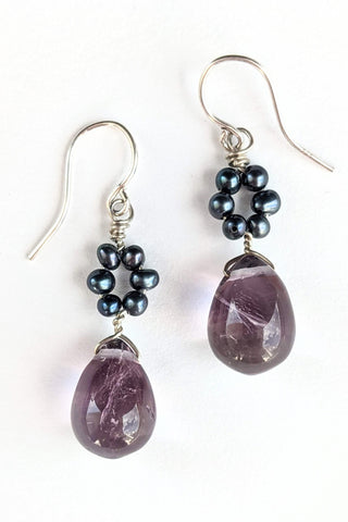 Daisy Drop gemstone earrings with amethyst teardrop and black freshwater pearl "flowers." Delicate purple and silver earrings by jewelry artisan Alison Jefferies for J'Adorn Designs