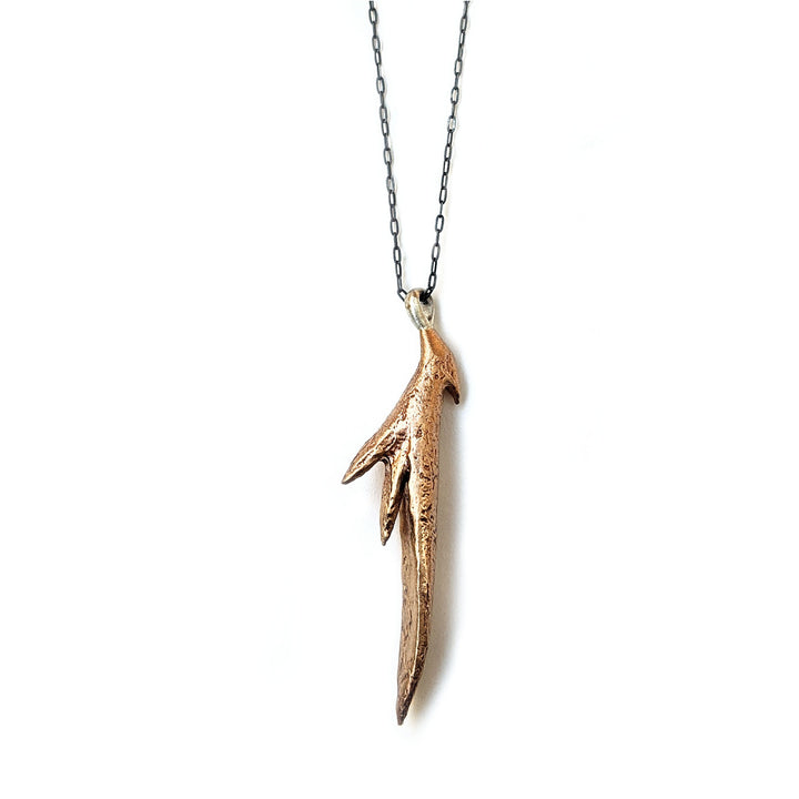 Natural bronze casting of a succulent aloe leaf pendant with a black oxidized sterling silver chain. Long black and gold handmade necklace by J'Adorn Designs jewelry artist Alison Jefferies.