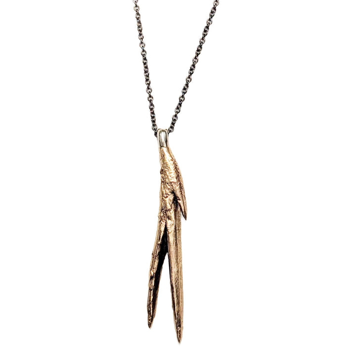 Natural bronze casting of a succulent aloe leaf pendant with a black oxidized sterling silver chain. Long black and gold handmade necklace by J'Adorn Designs jewelry artist Alison Jefferies.