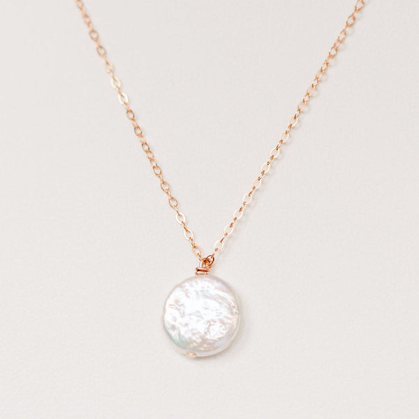 Delicate freshwater pearl pendant necklace in rose gold. One white freshwater coin pearl on a fine rose gold chain by J'Adorn Designs jewelry designer Alison Jefferies