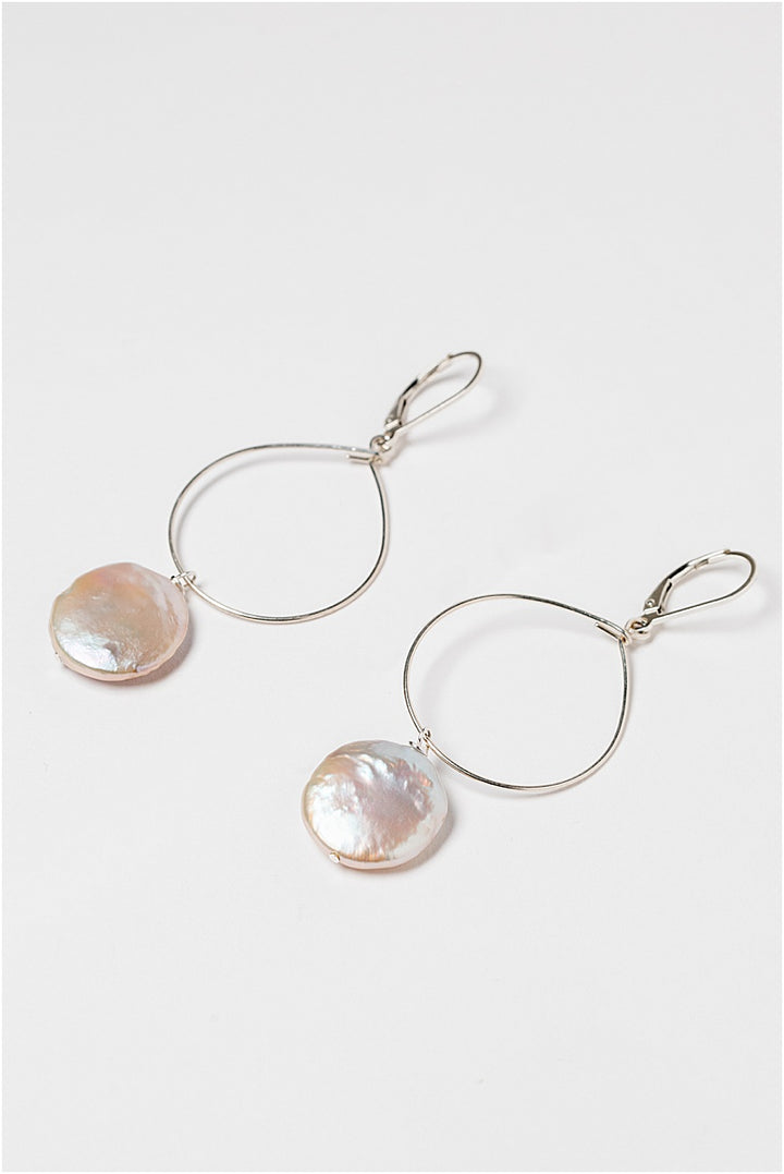 Lightweight silver hoop earrings with large pearl drops. Freshwater coin pearls on a thin silver hoop earrings. Handcrafted jewelry and modern bridal accessories by J'Adorn Designs artist Alison Jefferies.