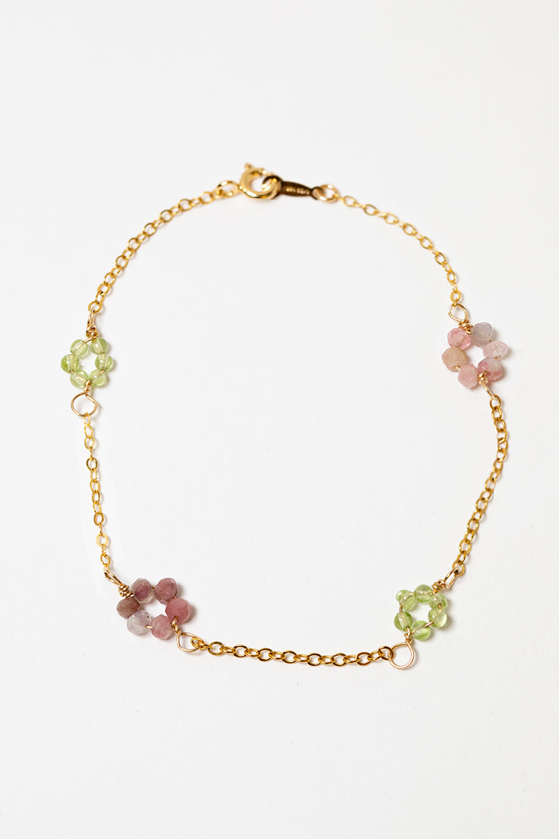 Dainty gold chain bracelet with pink tourmaline and green peridot gemstone flowers. Daisy Collection of jewelry by Alison Jefferies for J'Adorn Designs