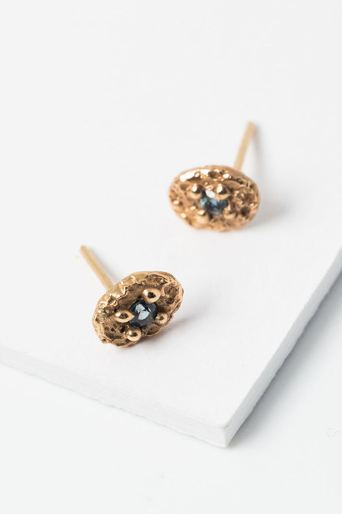 14k gold and light blue sapphires in a textured oval setting, handcrafted everyday sapphire stud earrings by Alison Jefferies for J'Adorn Designs