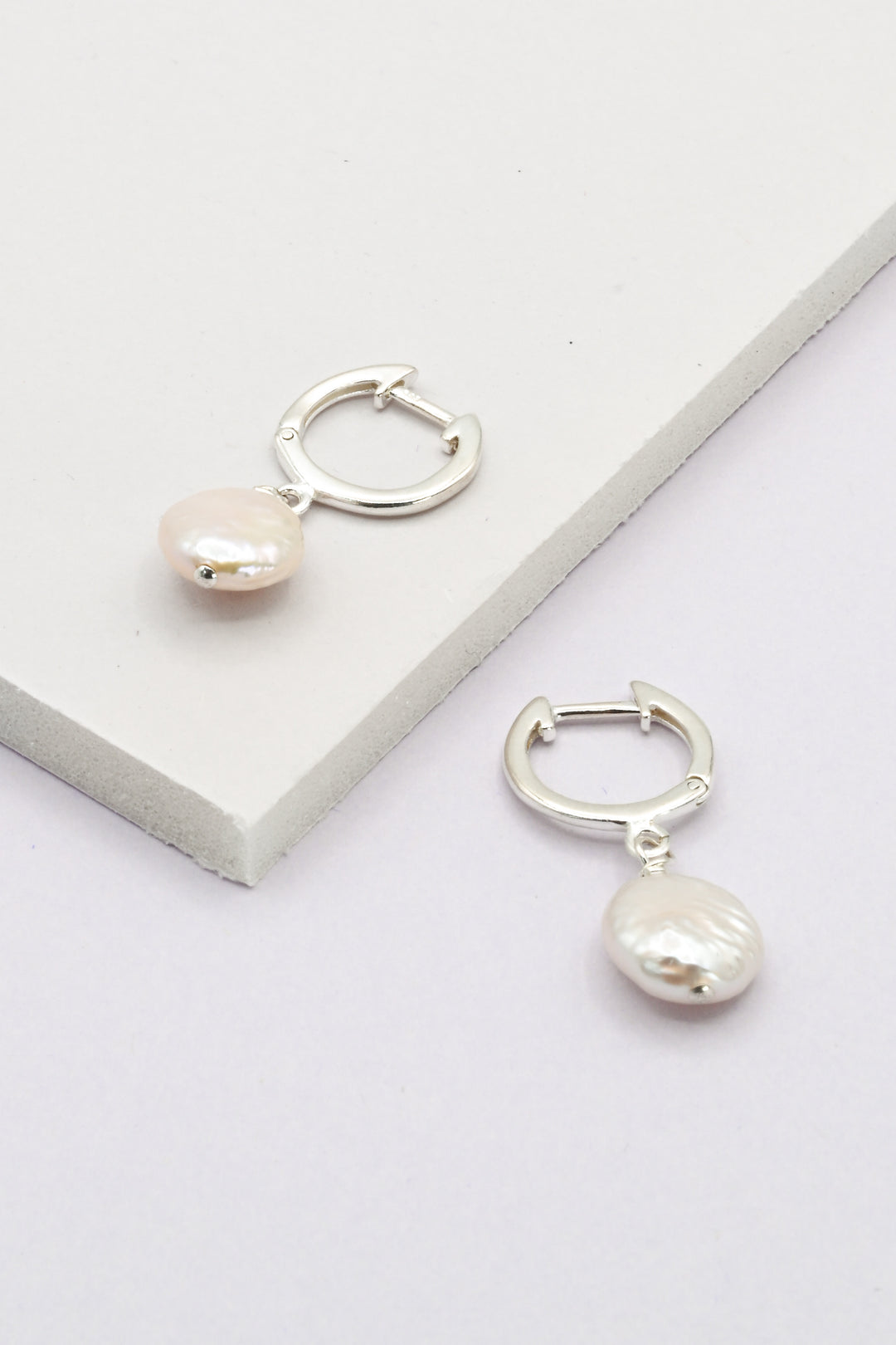 Silver hinged huggie hoop earrings with freshwater coin pearl drops.
