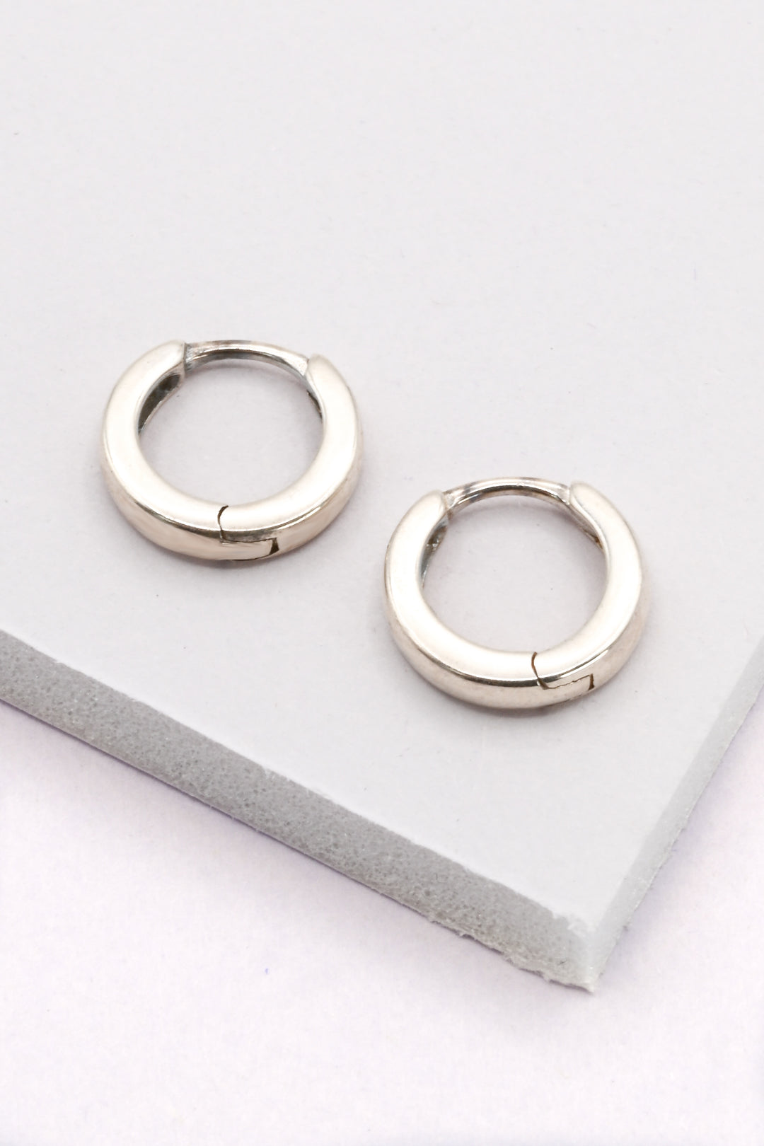 10mm hinged sterling silver huggie hoops on a white background