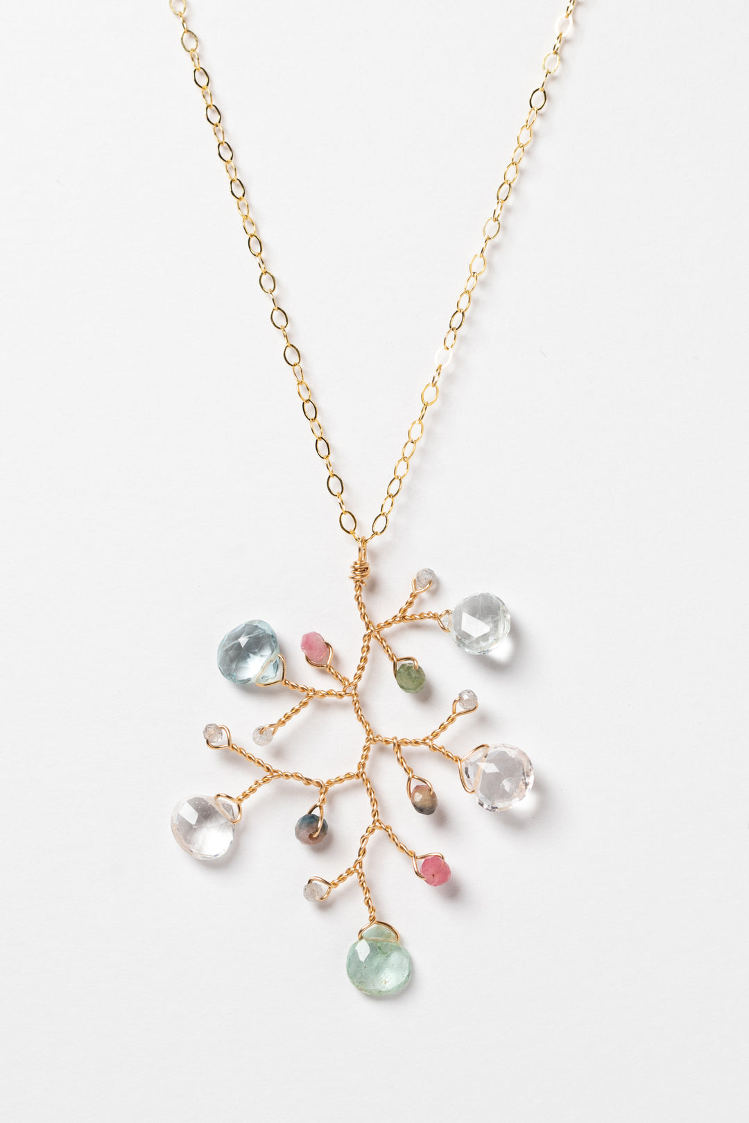One handcrafted gold pendant featuring a wire-wrapped branch with aquamarine teardrops and tourmaline beads in a rainbow of colors. A lightweight, hypoallergenic gemstone necklace on a fine 14k gold filled chain. Artisan jewelry made by Alison Jefferies for J'Adorn Designs.