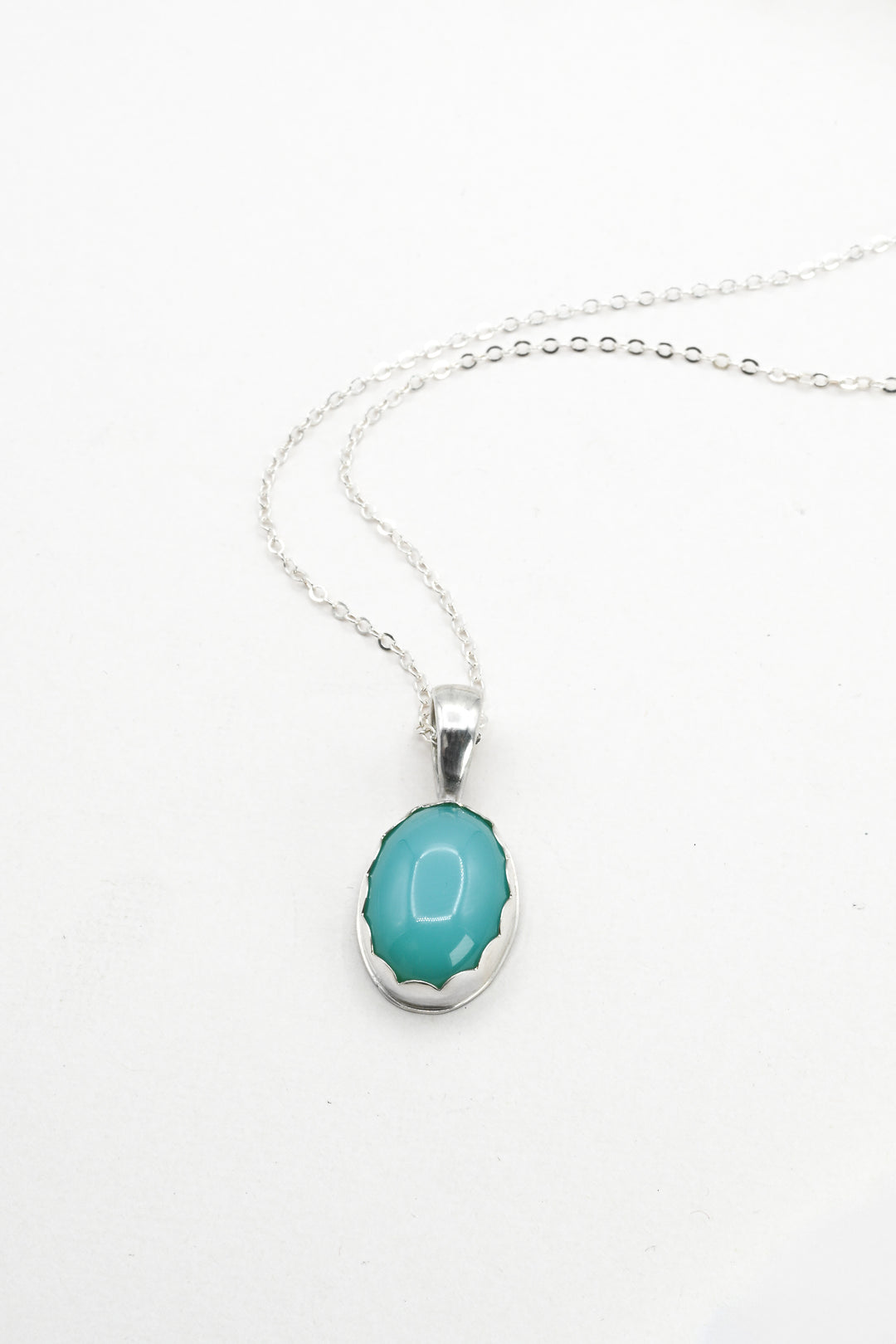 Turquoise aquaprase and silver pendant necklace on a white background