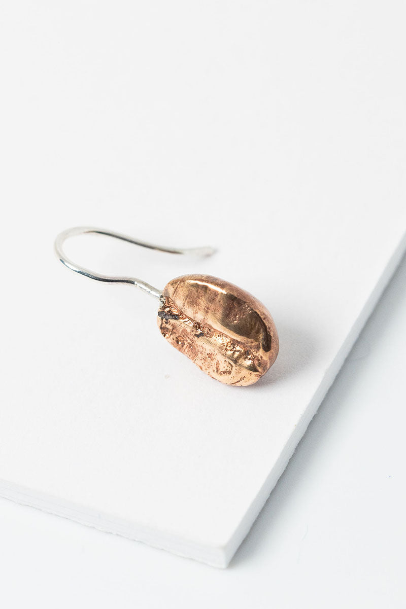 Single bronze coffee bean earring with a sterling silver hook. Unisex earring style to mix and match or wear alone. Gender inclusive jewelry by J'Adorn Designs.