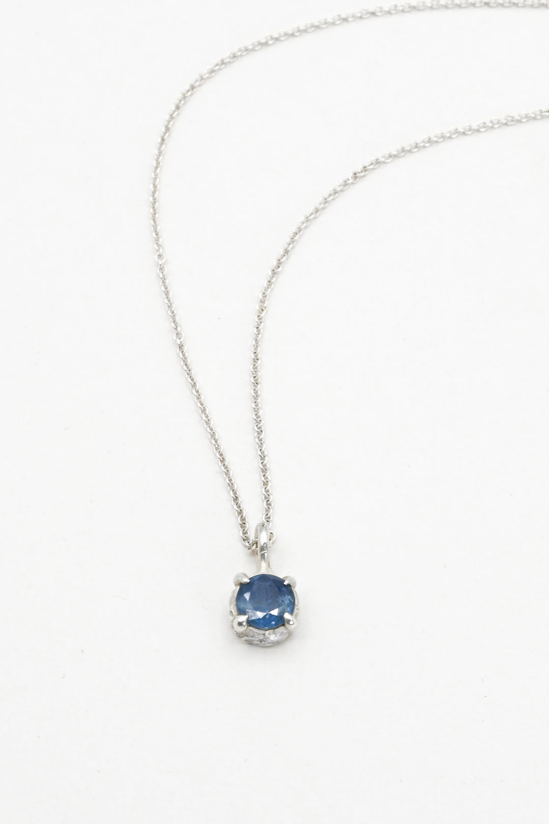 Round blue sapphire in a pronged sterling silver cast setting on a delicate silver chain by J'Adorn Designs