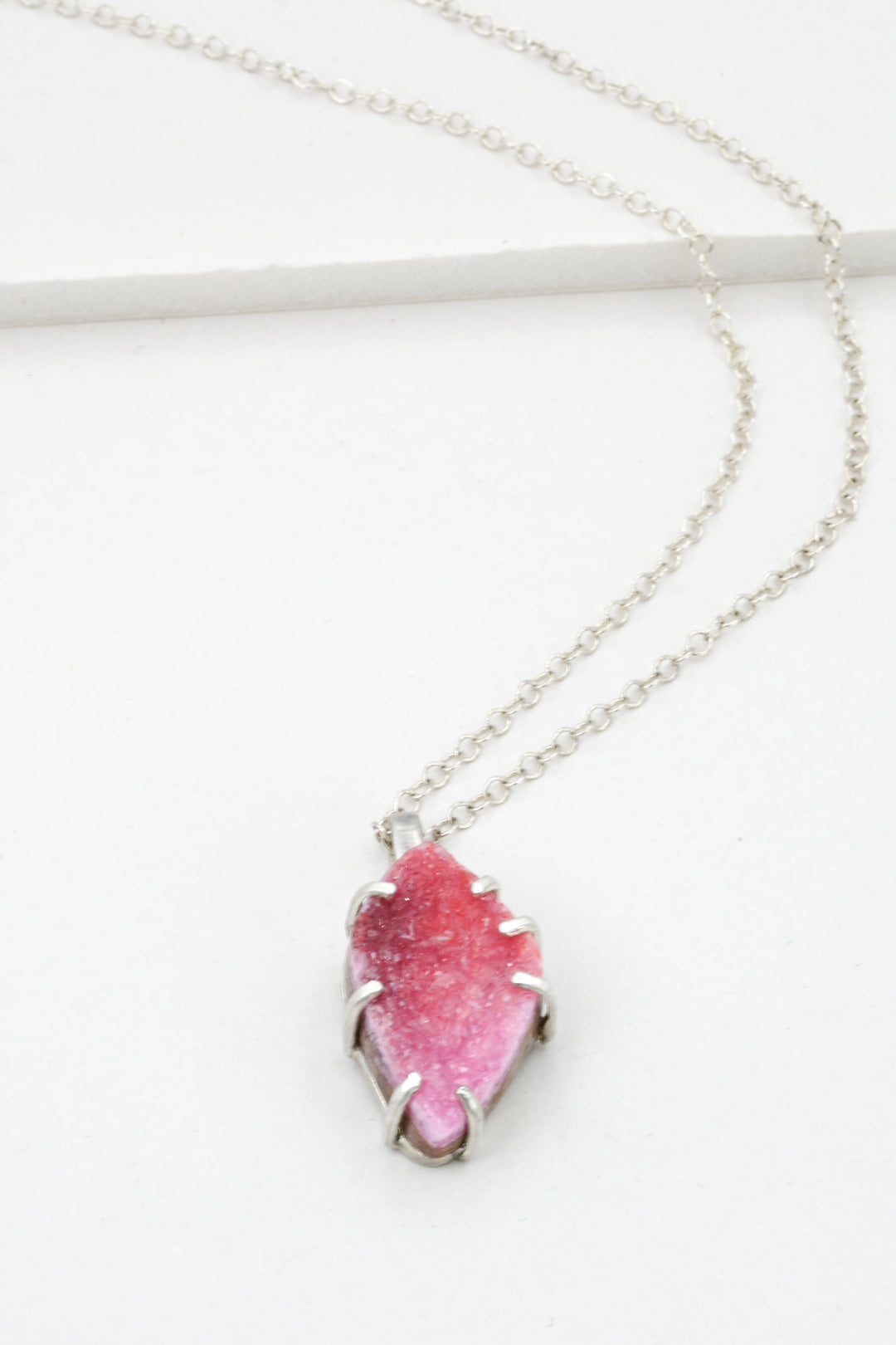 Sterling silver necklace with a pink cobaltocalcite pendant on a white background