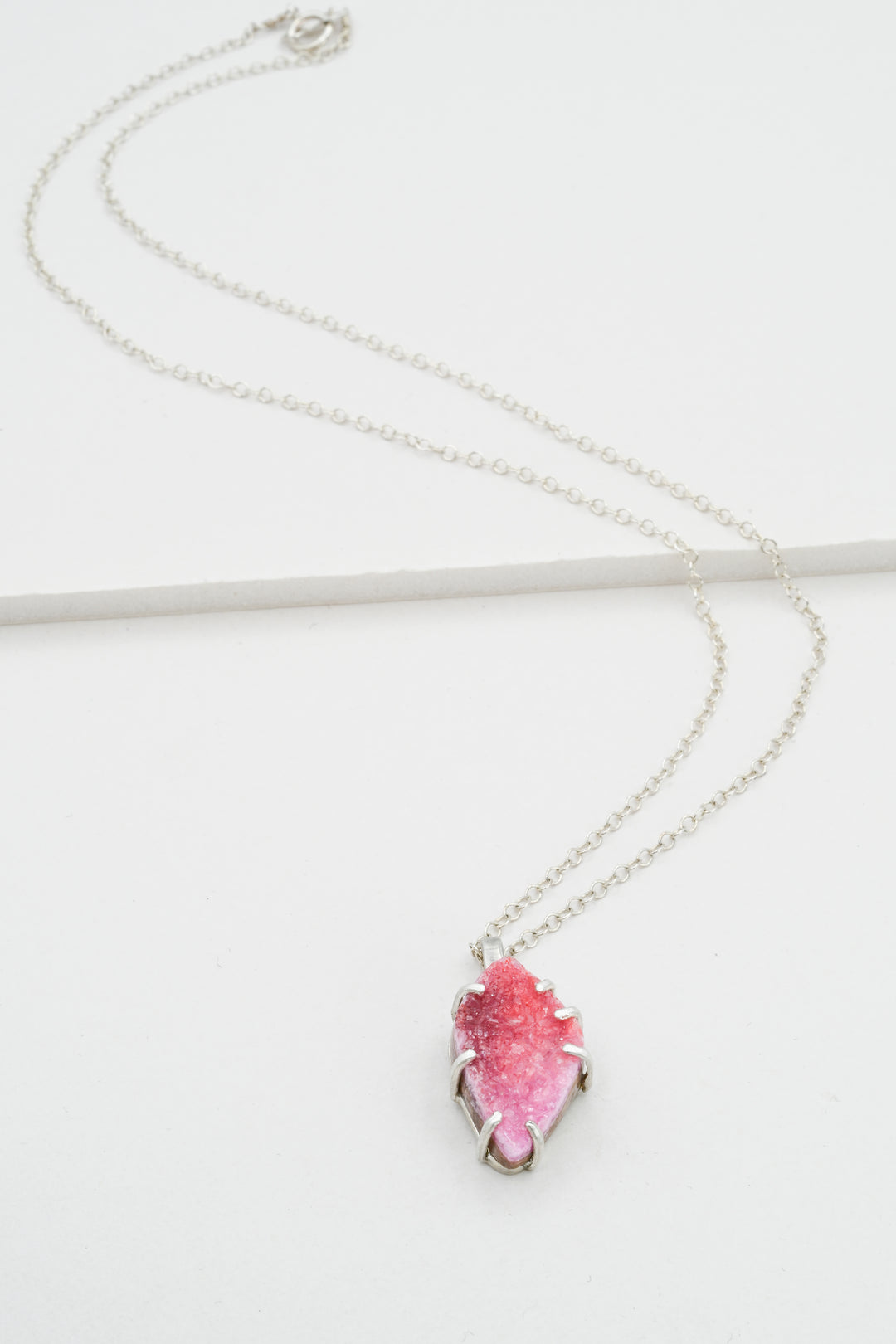 Sterling silver necklace with a pink cobaltocalcite pendant on a white background