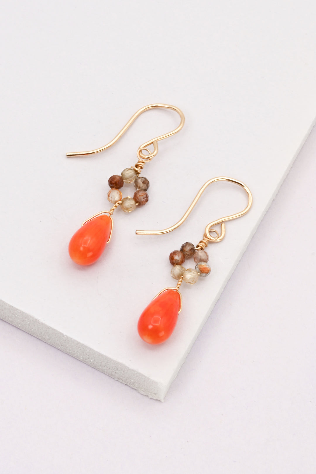 Coral and zircon daisy drop earrings with gold earring hooks on a white background
