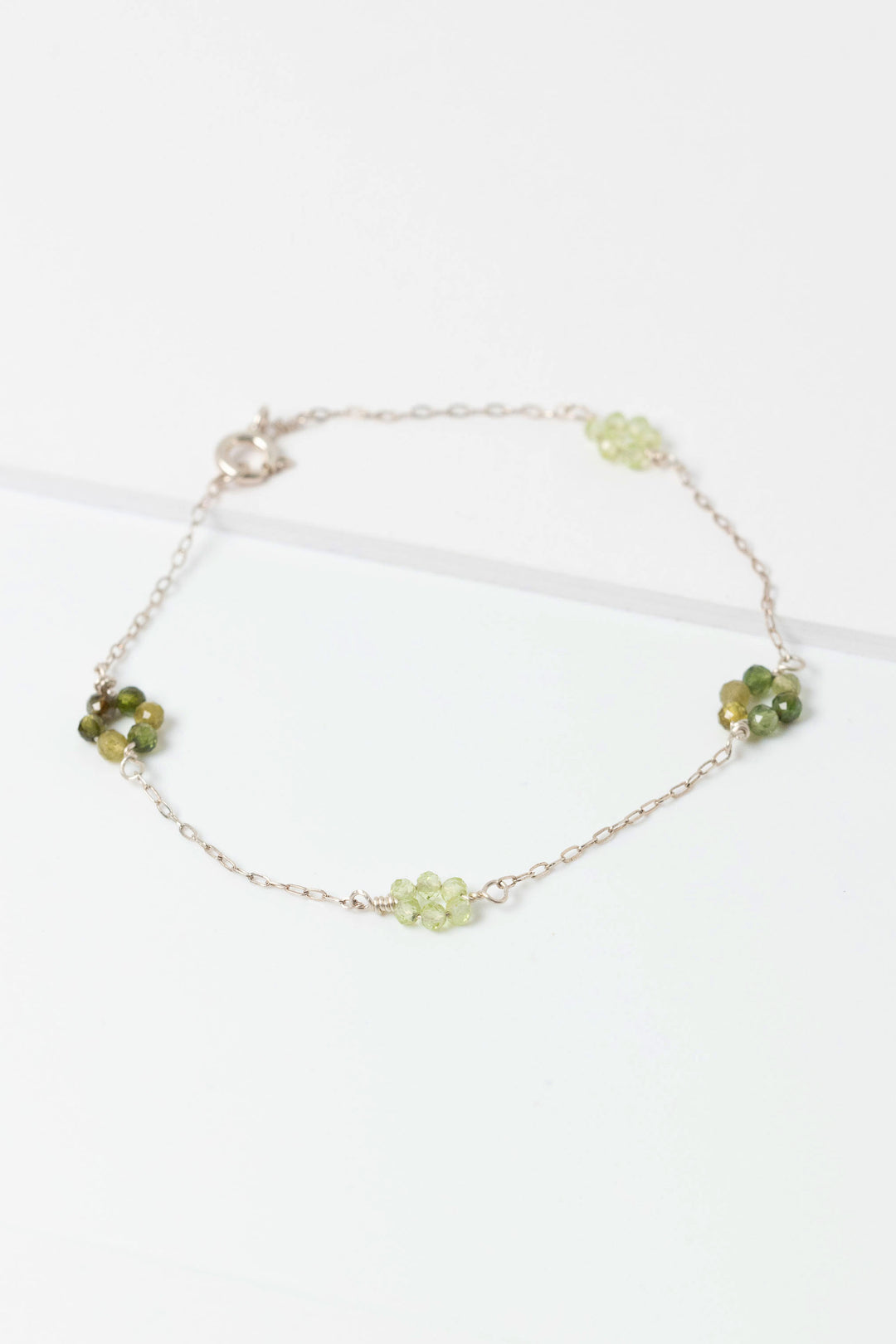 Sterling siliver "daisy chain" link bracelet with green tourmaline and peridot gemstone flowers on a dainty sterling silver chain.