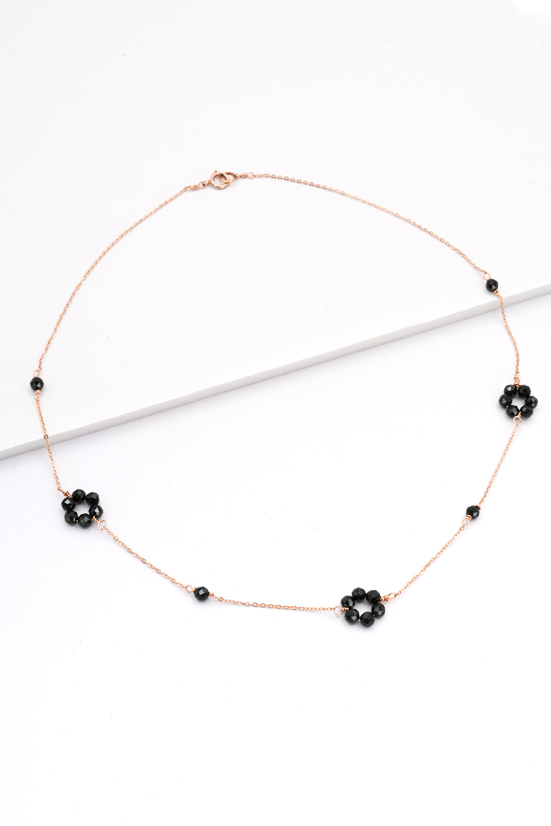 Rose gold daisy chain necklace with black spinel gemstone flowers by J'Adorn Designs