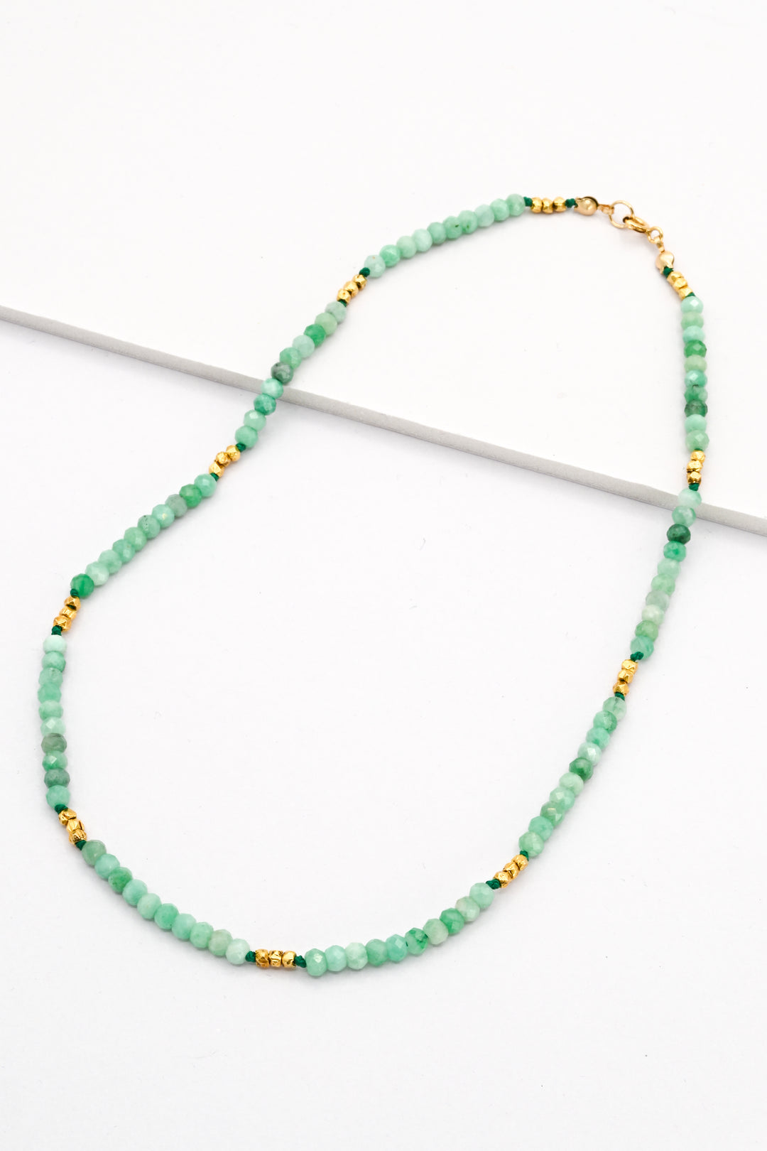 Emerald and gold vermeil beaded necklace on a white background.