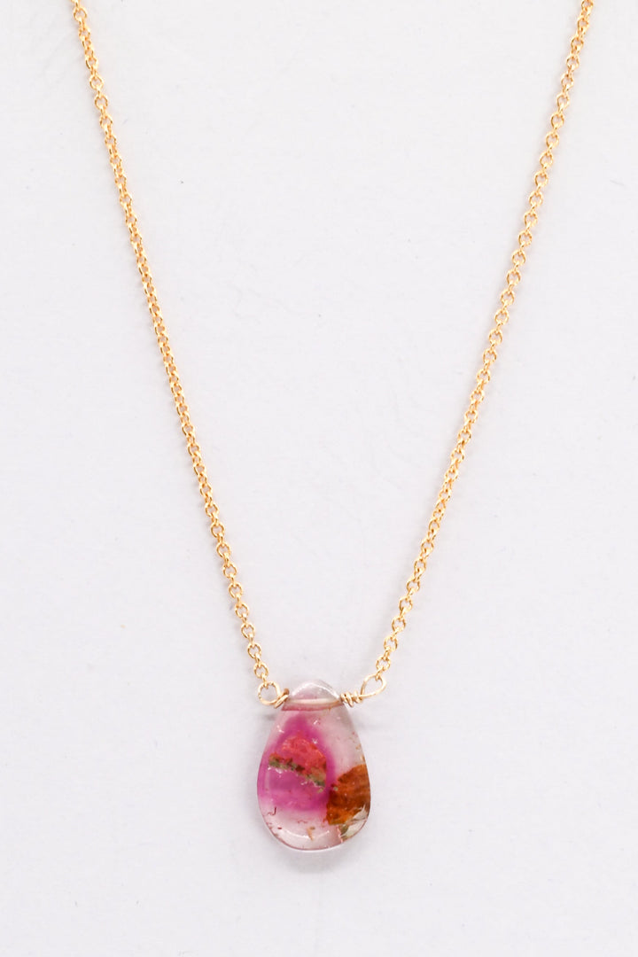 Gold necklace with a teardrop-shaped watermelon tourmaline pendant on a white background