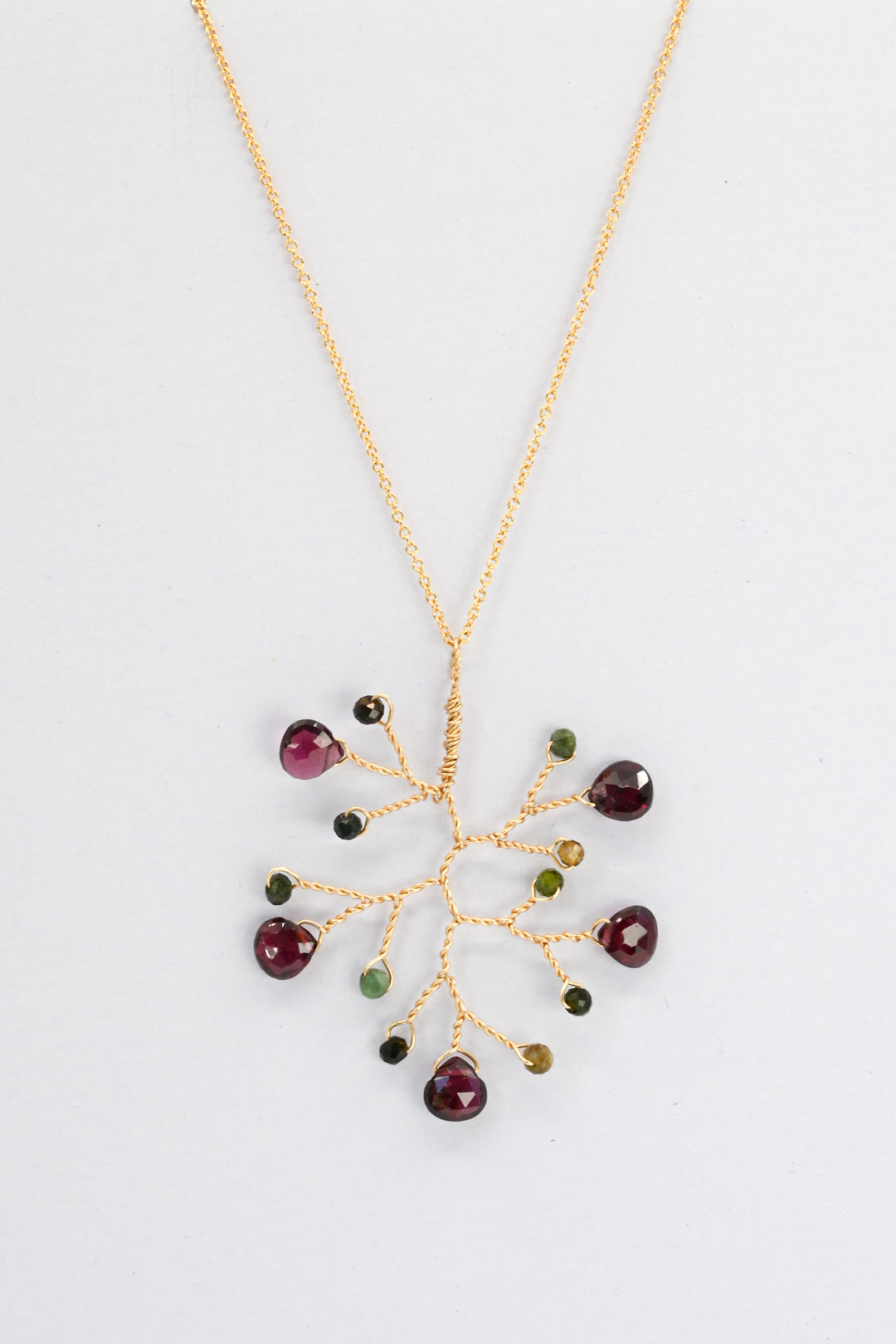Gold wire wrapped branch pendant with garnet teardrops and earthy green and brown tourmaline accent beads on a delicate gold chain