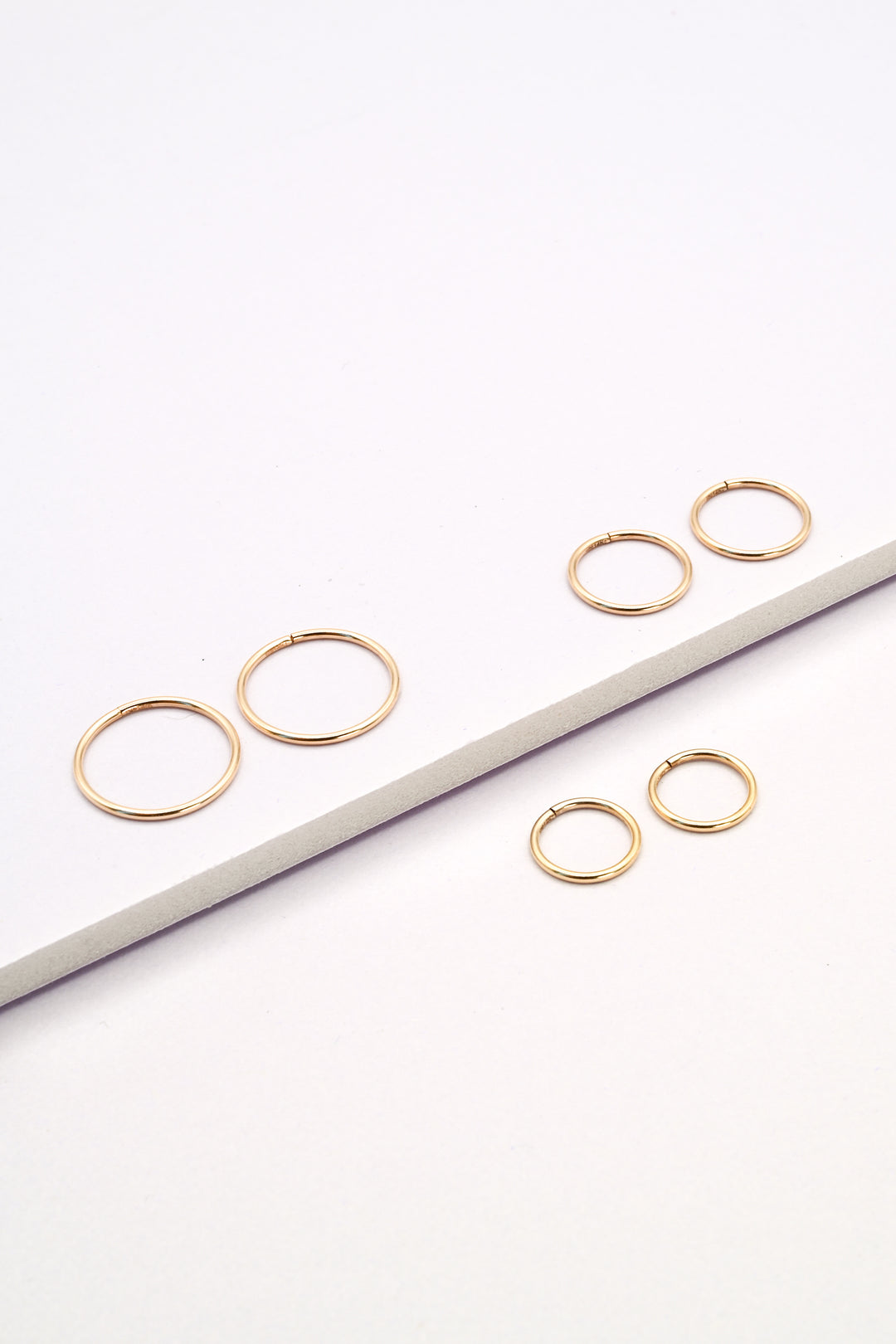 Small, medium, and large size seamless huggie hoop earrings in gold