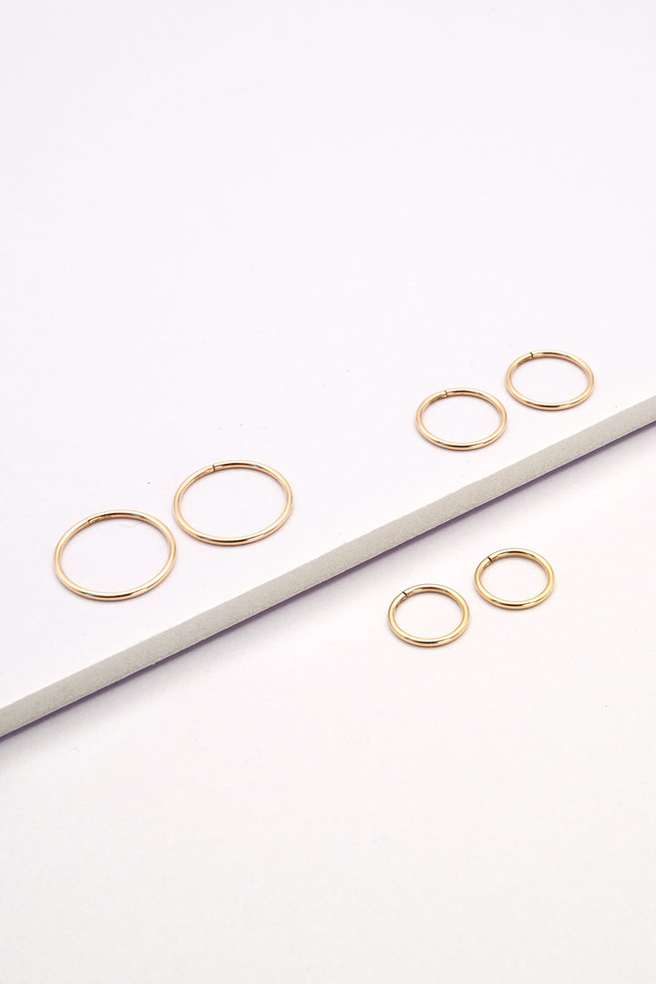 Small, medium, and large size seamless huggie hoop earrings in gold
