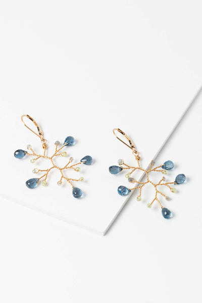 Flay lay view of London blue topaz, peridot, and labradorite gold branch earrings. Lightweight statement earrings inspired by nature, made by jewelry artist Alison Jefferies for J'Adorn Designs Custom Jewelry.