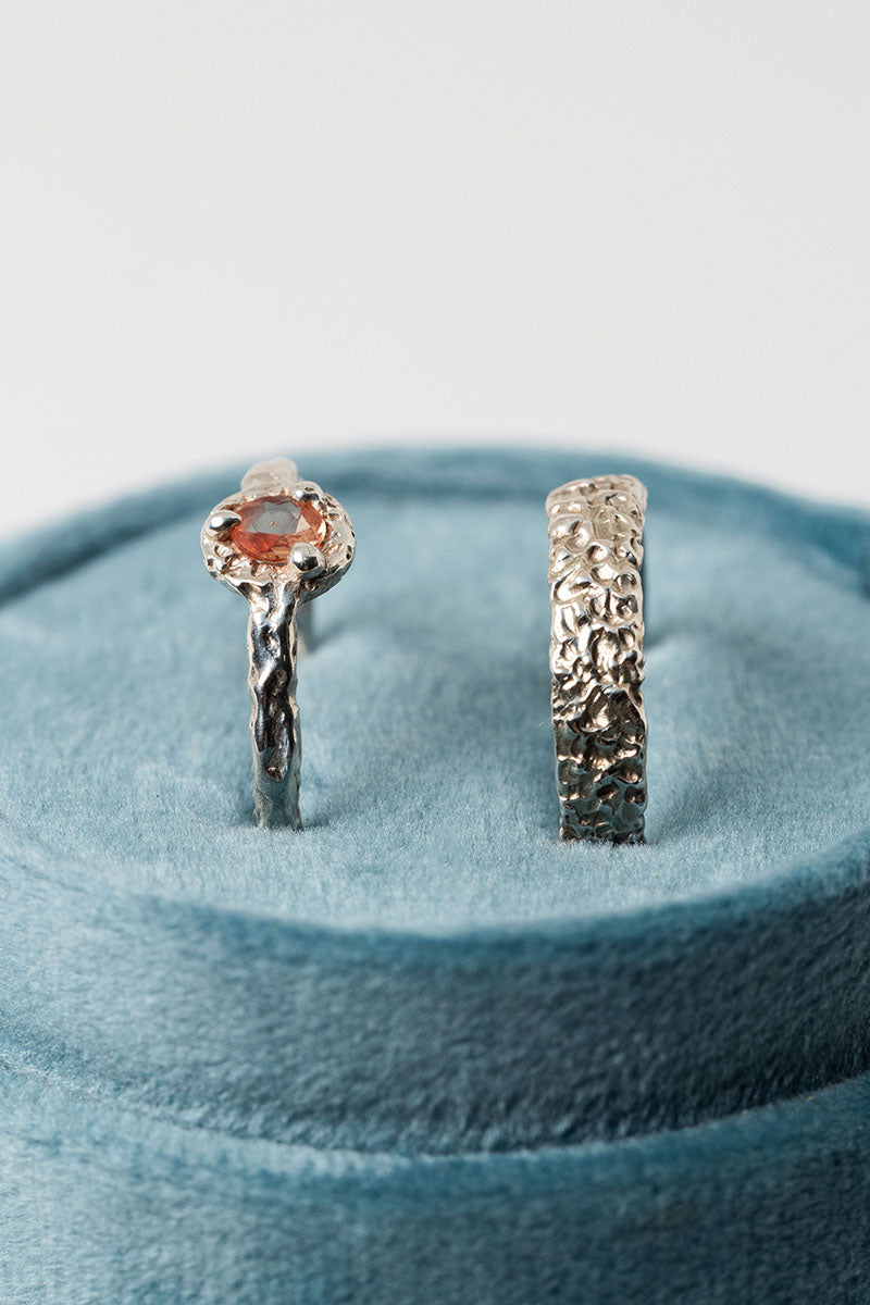 Sterling silver textured crater band stacking ring  and textured peach sapphire solitaire ring in a teal double ring box