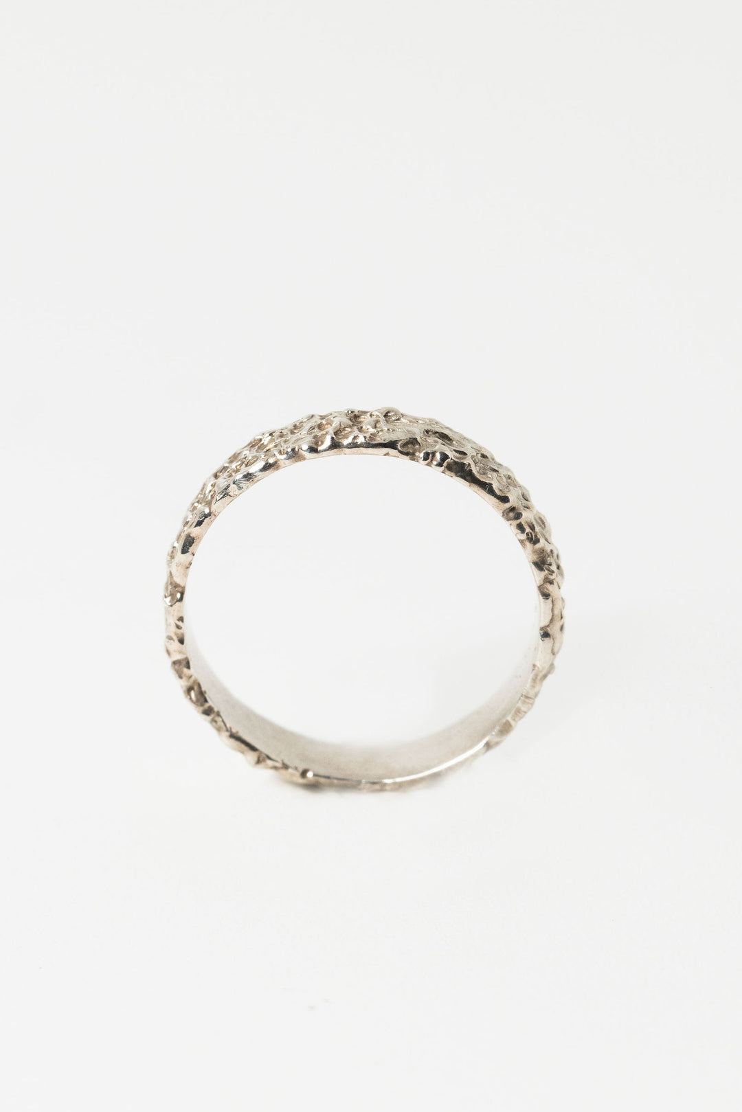 Side view of sterling silver textured crater band stacking ring by J'Adorn Designs