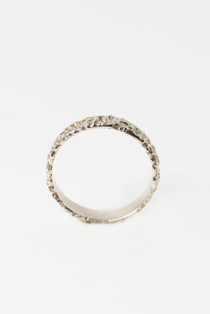 Side view of sterling silver textured crater band stacking ring by J'Adorn Designs