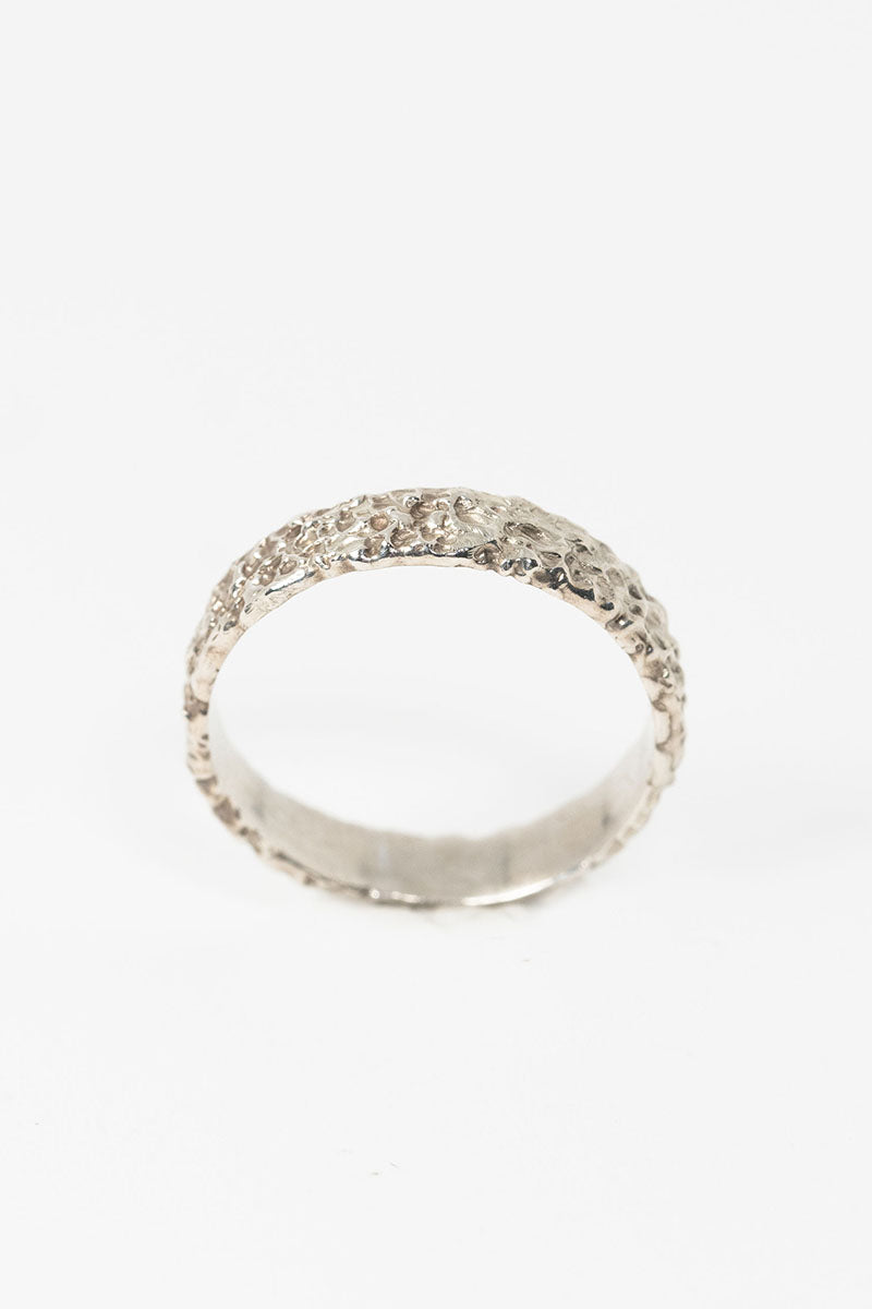 Top side view of sterling silver textured crater band stacking ring by J'Adorn Designs