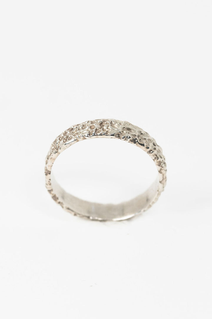Top side view of sterling silver textured crater band stacking ring by J'Adorn Designs