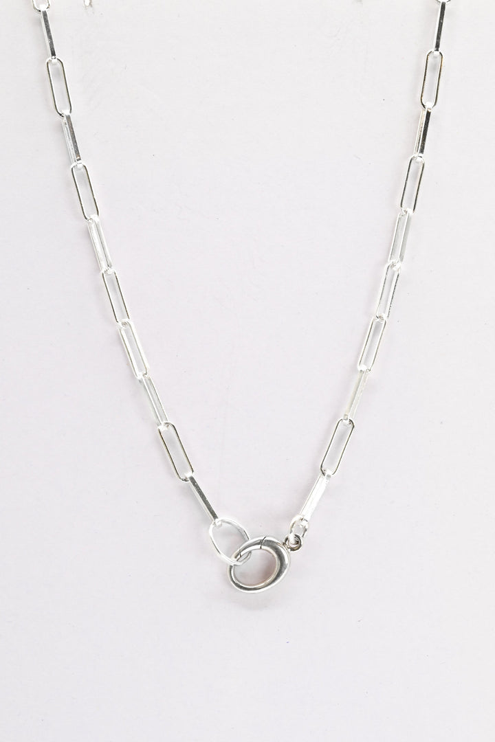 Sterling silver paperclip chain with charm holder clasp on a white background