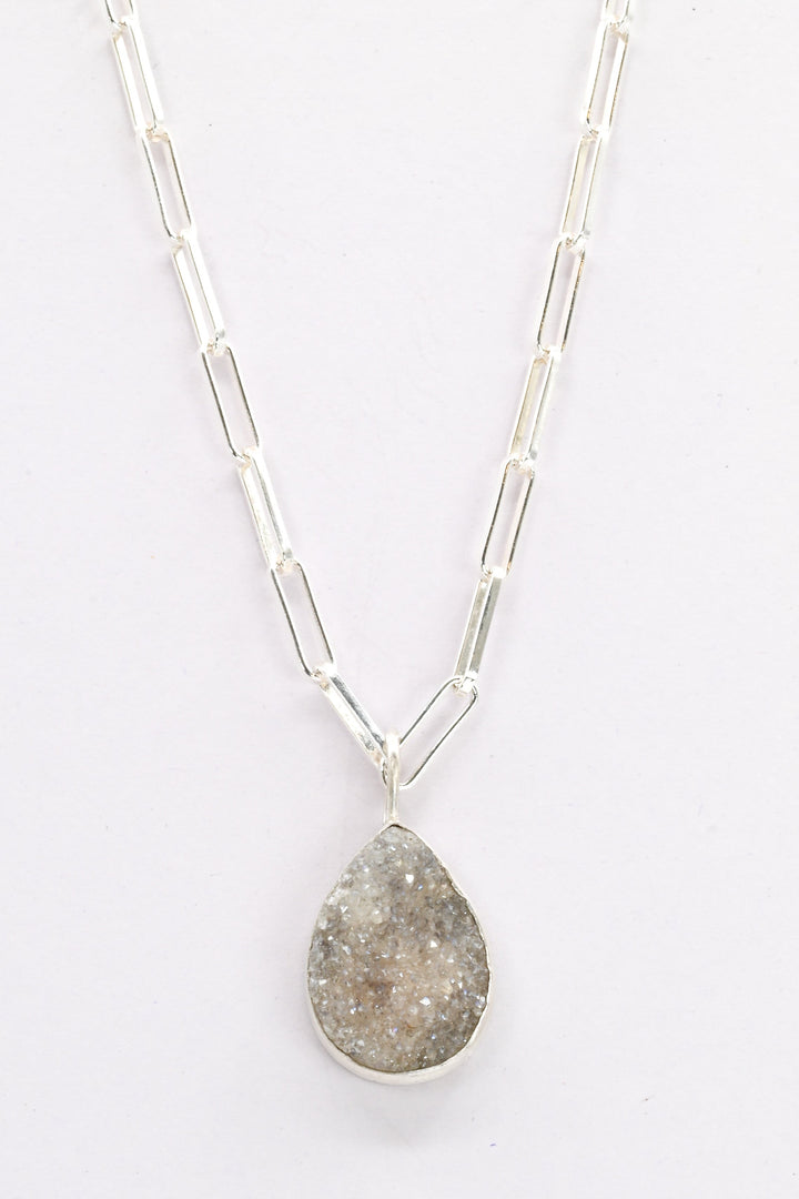 Sterling silver necklace with a purple druzy teardrop-shaped pendant on a white background