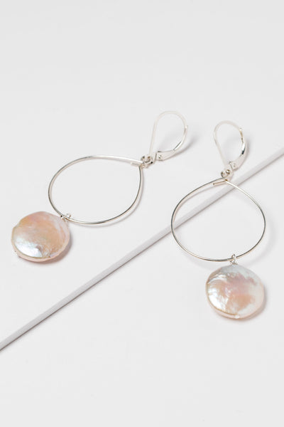 Lightweight silver hoop earrings with large pearl drops. Freshwater coin pearls on a thin silver hoop earrings. Handcrafted jewelry and modern bridal accessories by J'Adorn Designs artist Alison Jefferies.