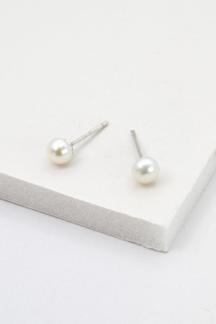 Tiny pearl stud earrings in sterling silver