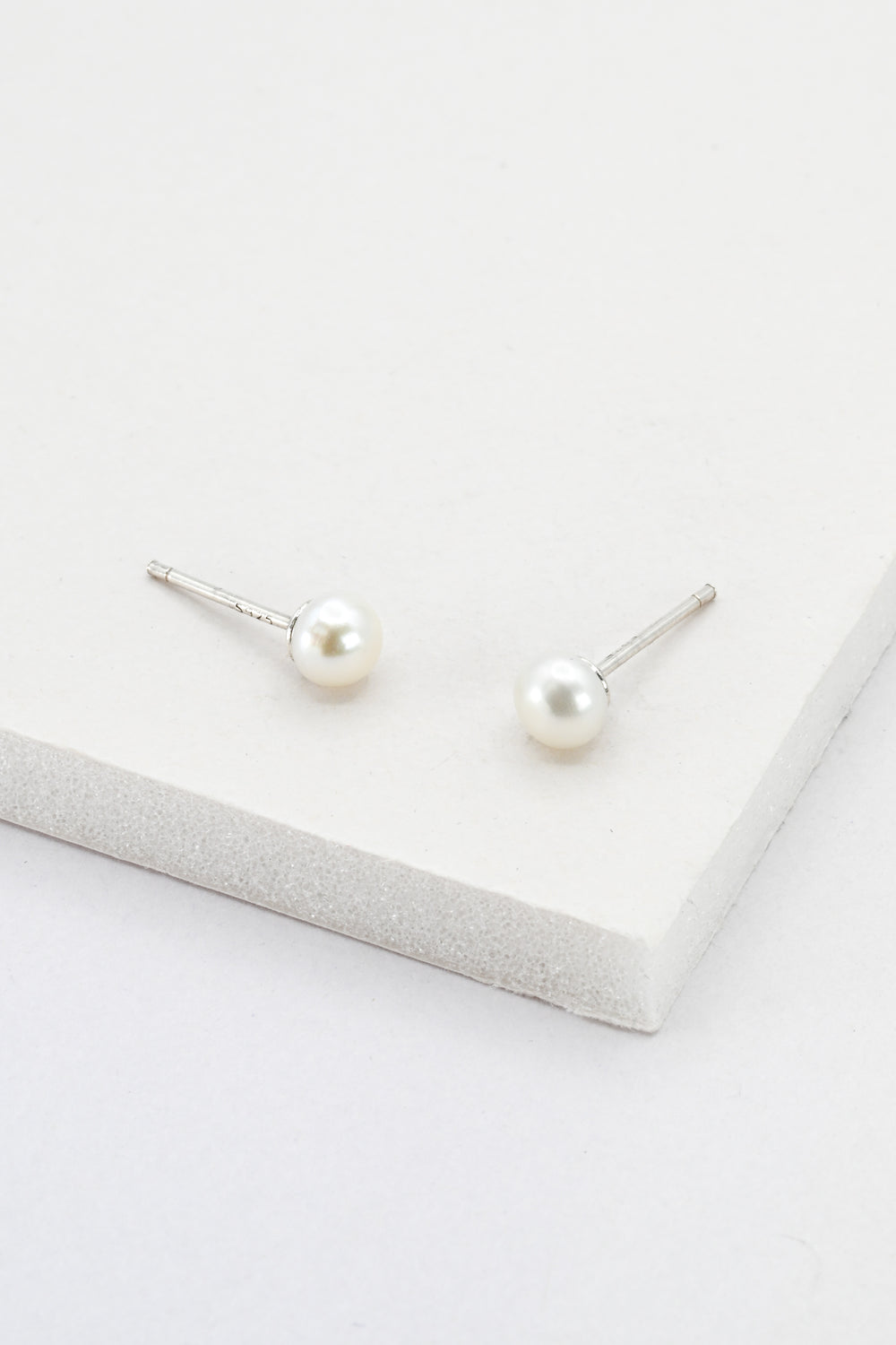 A pair of small pearl stud earrings with sterling silver posts