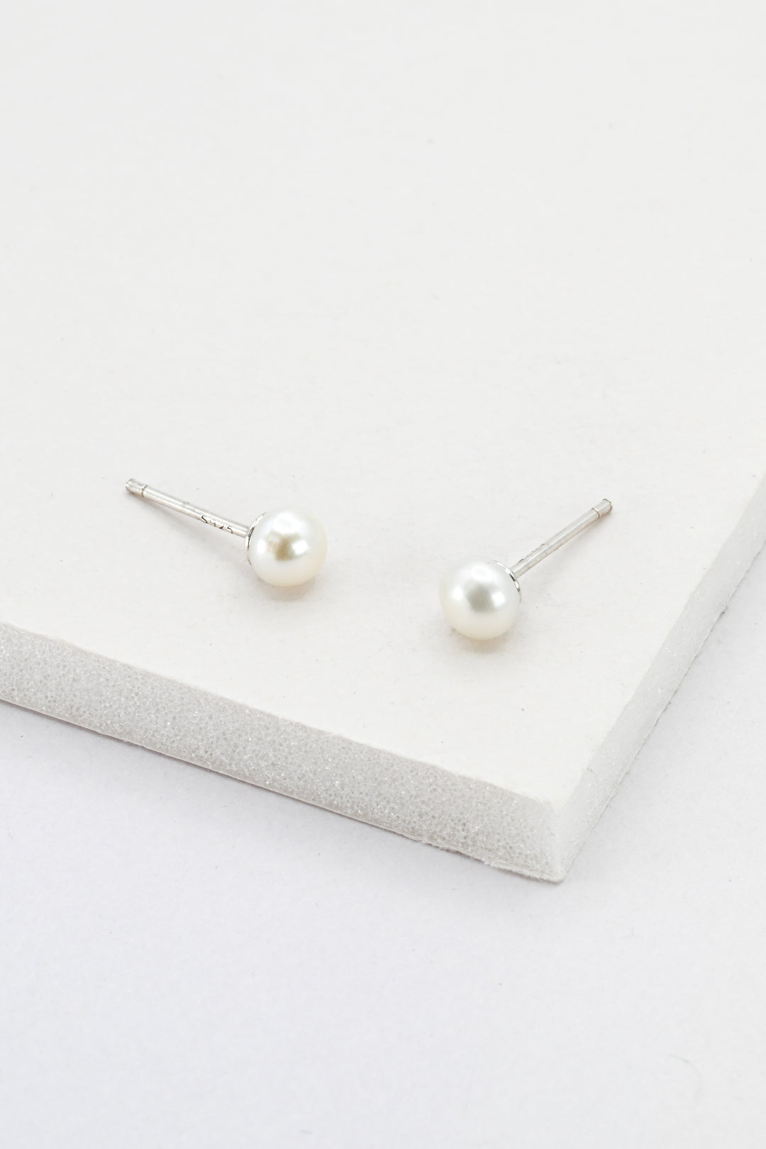 A pair of small pearl stud earrings with sterling silver posts