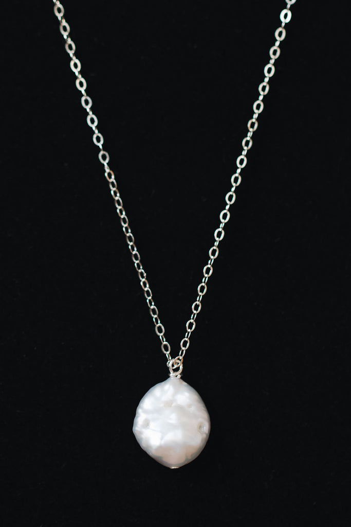 Delicate freshwater pearl pendant necklace in sterling silver. One white freshwater coin pearl on a fine silver chain by J'Adorn Designs jewelry designer Alison Jefferies
