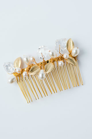 An heirloom quality gold plated hair comb is adorned with hand-wired ivory pearls, genuine crystal quartz gemstone nuggets, and gold leaves. Handmade bridal comb for wedding hairstyles, formals, and special occasions for years to come by jewelry artisan Alison Jefferies for J'Adorn Designs.