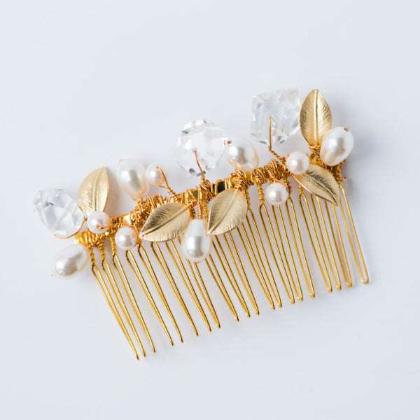 An heirloom quality gold plated hair comb is adorned with hand-wired ivory pearls, genuine crystal quartz gemstone nuggets, and gold leaves. Handmade bridal comb for wedding hairstyles, formals, and special occasions for years to come by jewelry artisan Alison Jefferies for J'Adorn Designs. 