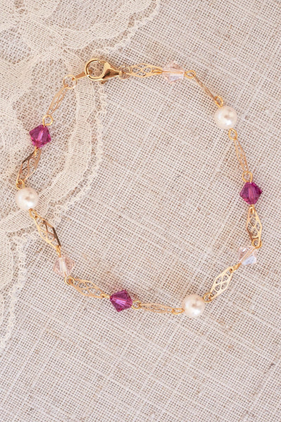 Hot pink and clear crystals, pearls, and 14k gold fill filigree links make up this delicate pink bracelet by J'Adorn Designs artist Alison Jefferies.