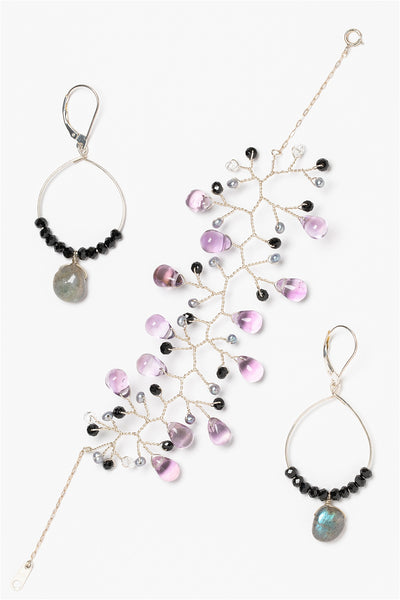 Silver vine cuff bracelet with amethyst teardrops, grey freshwater pearls, and black spinel gemstones. Silver hoop earrings with labradorite drops and black spinel accent beads. Gemstone jewelry set made by jewelry artisan Alison Jefferies of J'Adorn Designs custom jeweler in Maryland.