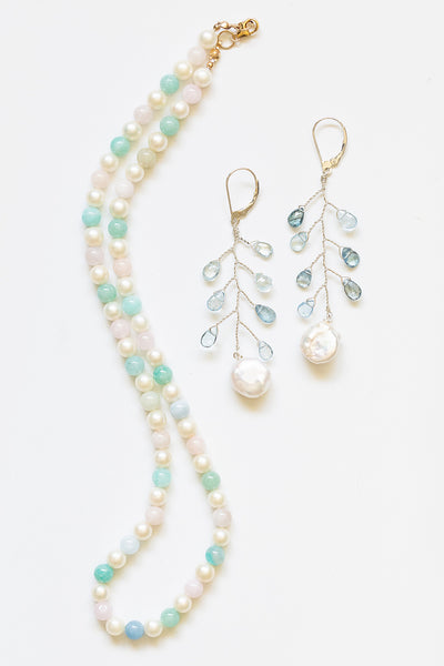 One handcrafted strung pearl necklace in rainbow pastel colors, made with white freshwater pearls and beryl beads with a 14k gold filled clasp. The pearl necklace is paired with delicate aquamarine and coin pearl vine earrings.Artisan jewelry and luxury bridal accessories handmade in Maryland by Alison Jefferies of J'Adorn Designs.