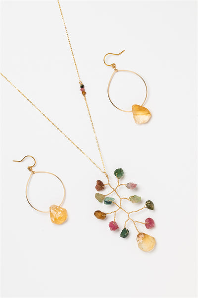 Long asymmetrical necklace with rough rainbow tourmaline and citrine gemstones in a wire wrapped branch design. Coordinated gold hoop earrings with rough citrine drops. Gold jewelry set made by J'Adorn Designs artisan Alison Jefferies of Baltimore, MD.
