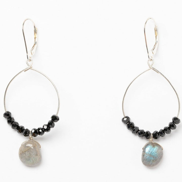 A pair of black and silver hoop earrings with black spinel and iridescent grey labradorite drops. Celestial inspired jewelry for luxury fashion or a jewelry gift idea. Artisan jewelry and luxury bridal accessories handmade in Maryland by Alison Jefferies of J'Adorn Designs.